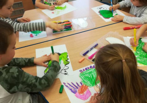 Dzieci przy stolikach rysują smoka wawelskiego.